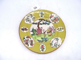 A hand painted terracotta plate having green background,