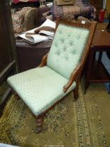 A Mahogany framed lady's Fireside Chair standing on turned front legs and upholstered in lattice