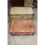 A green canvas luggage case having brown leather corners, straps, handles, etc.