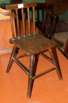 A darkwood child's comb back Side Chair standing on sloping turned legs with turned stretchers,