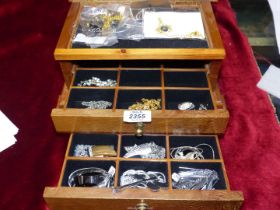 A wooden jewellery Box with two drawers containing white metal costume jewellery necklaces.