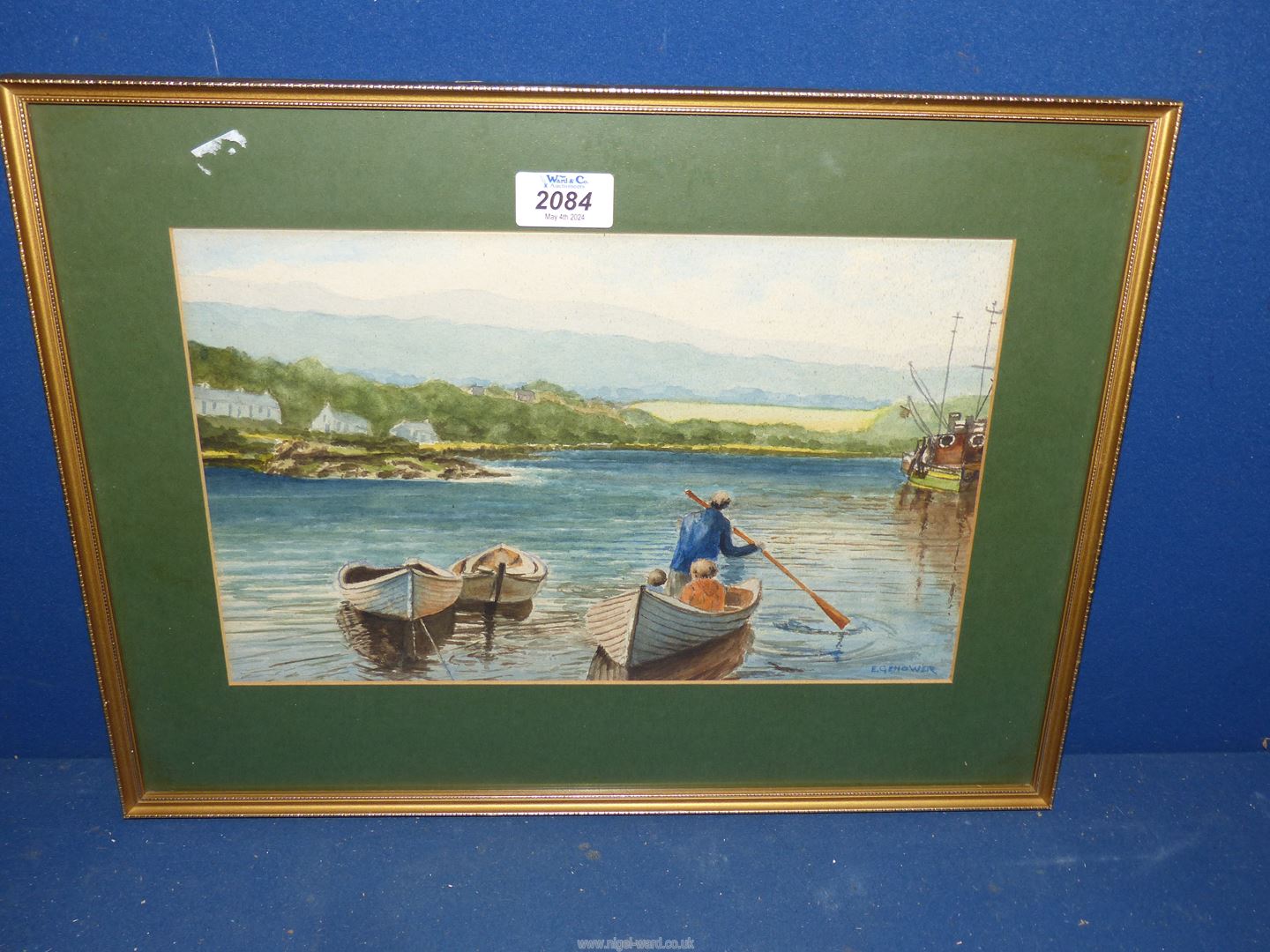 A framed and mounted Watercolour with figures in a Rowing boat, rolling hills in the background.