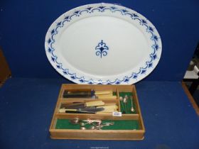 A wooden cutlery tray containing a quantity of bone handled knives,