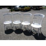Four white painted country style chairs and a rocking chair.