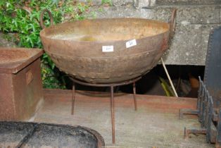 A riveted fire pit on stand, 21 1/2" wide x 17 1/2" high.