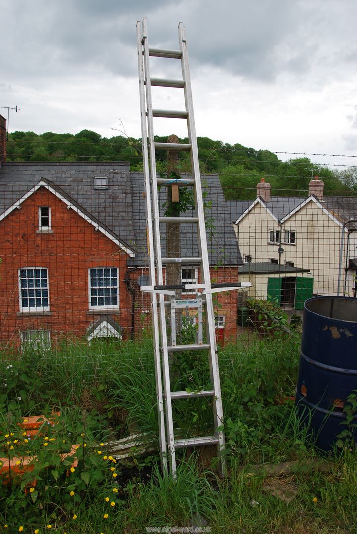 A 11 rung aluminium extending ladder with a stand off.