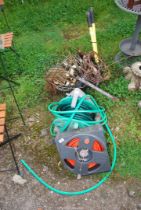 A quantity of hanging baskets, garden tools and two hoses on reels.