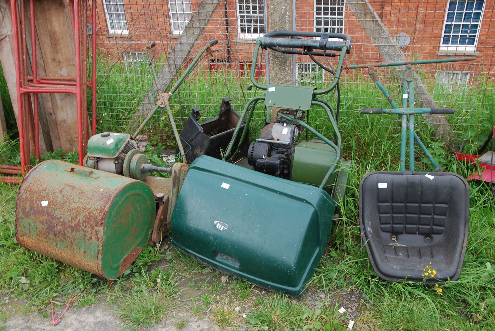 Two cylinder mowers, one with seat and roller, (engine turns) the other (as found).