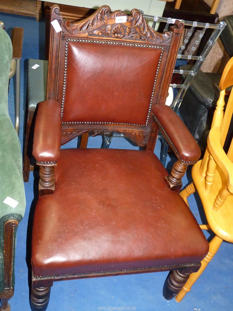 An Oak leather upholstered armchair.