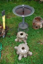 A Plastic bird bath and two carved stands.
