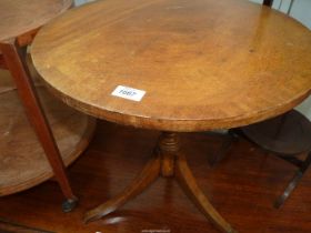 A cross-banded Mahogany occasional table standing on a turned pillar with three splay feet,