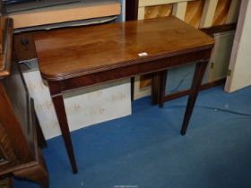 A Walnut/Mahogany flapover Tea Table standing on tapering square legs,