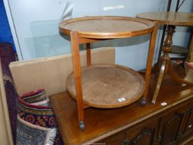 An Oak and other woods two tier circular table, the two shelves being removable circular trays.