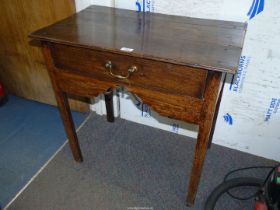 A Georgian Oak Side Table/Lowboy standing on square legs and having a frieze drawer with a drop