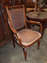 An Arts & Crafts type open armed Satinwood framed open armed Elbow Chair standing on turned front