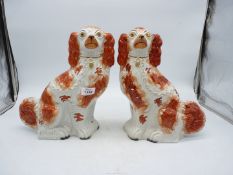 A pair of Victorian Staffordshire spaniel dogs in russet red and white, 12" tall.