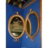 A pair of Gilt gesso oval mirrors with bevel plate,