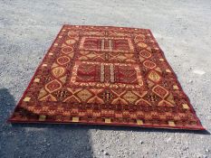 A bordered and patterned red ground Carpet in geometric pattern, 111 1/2