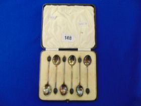 A boxed set of enamel and Silver spoons