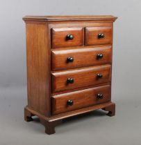 A miniature mahogany chest of drawers in the Victorian style. 44cm x 34cm x 19cm.