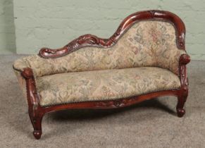 A Victorian style carved mahogany child's chaise lounge. Height 48cm, Length 80cm.