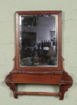 A mahogany hall mirror. Having bevel edge glass, glove compartment and rail to underside.