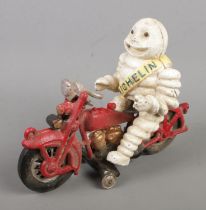 A cast iron model of the Michelin Man riding a motorcycle.