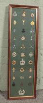 A large framed display of 31 military cap badges. Includes Gordon Highlanders, Gurkhas, Royal