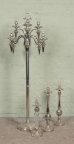 A large chromed eight branch standing candelabra, together with three chromed candlesticks of