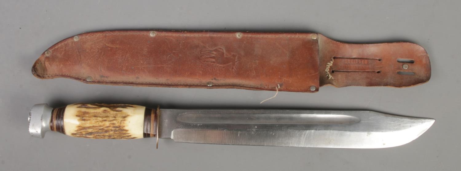 A large Solingen bowie knife with associated leather sheath. Blade length 31cm. CANNOT POST OVERSEAS