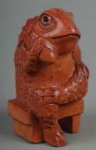 A hand carved hardwood netsuke of a sitting frog