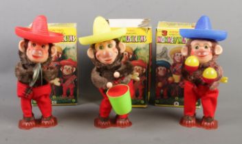 A complete set of three boxed wind up Mechanical Monkey Musicians to include drum, cymbals and