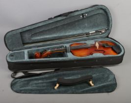 A cased Primavera two piece back 3/4 violin with bow. Back length of violin 34cm.