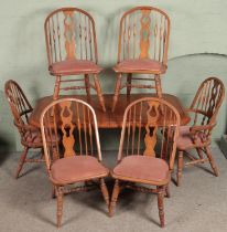 A large mahogany dining table along with a set of six spindle back chairs.