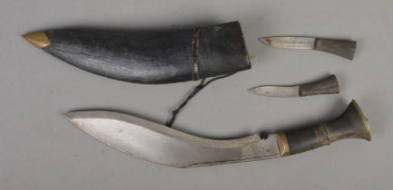 An Indian Kukri knife in scabbard with two smaller accompanying knives. Length of blade