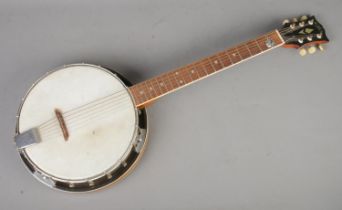 An Aria six string guitar banjo, with plectrum.