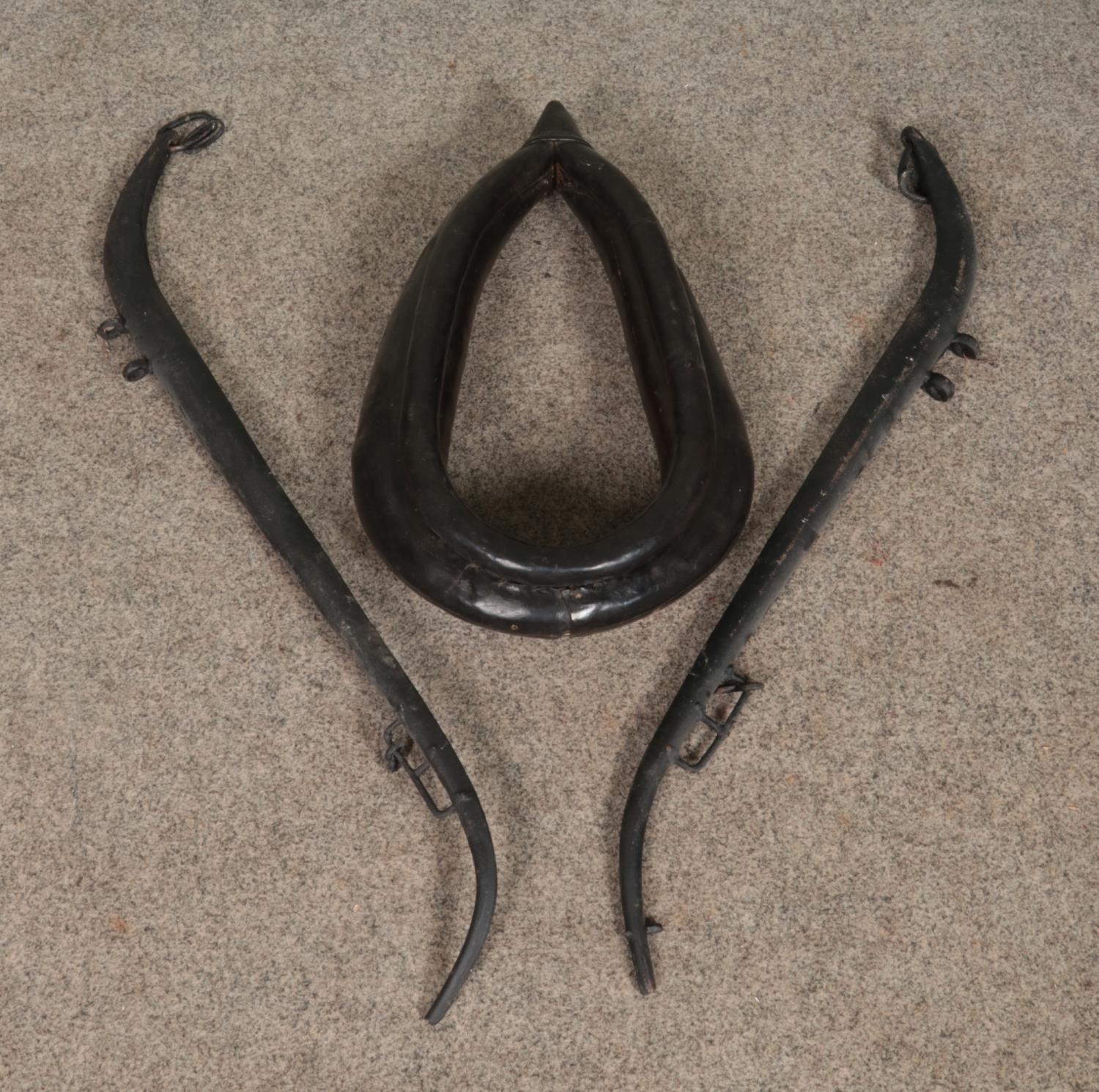 A small leather horse collar along with a pair of iron horse hames.