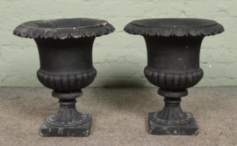 A pair of black painted terracotta garden urns, 46cm high.