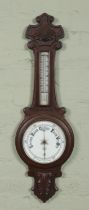 A carved oak banjo barometer. The dial marked for H Miller, Optician, Leeds.