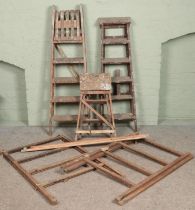 Three sets of wooden step ladders along with two clothes horses.