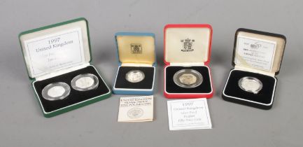 Four cased silver proof coins to include 1997 Fifty Pence two-coin set, Piedfort 50th Anniversary of