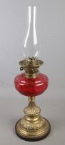 A Victorian Young's cranberry glass and brass oil lamp. (63cm)