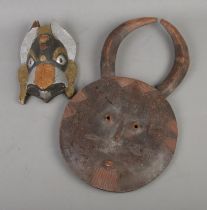 Two African carved tribal masks to include example featuring applied metalwork.