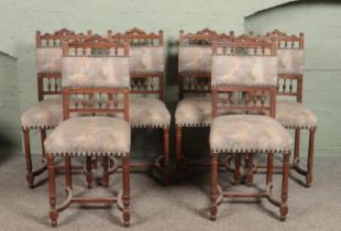 A set of six antique carved mahogany dining chairs with upholstered seats and back rests.