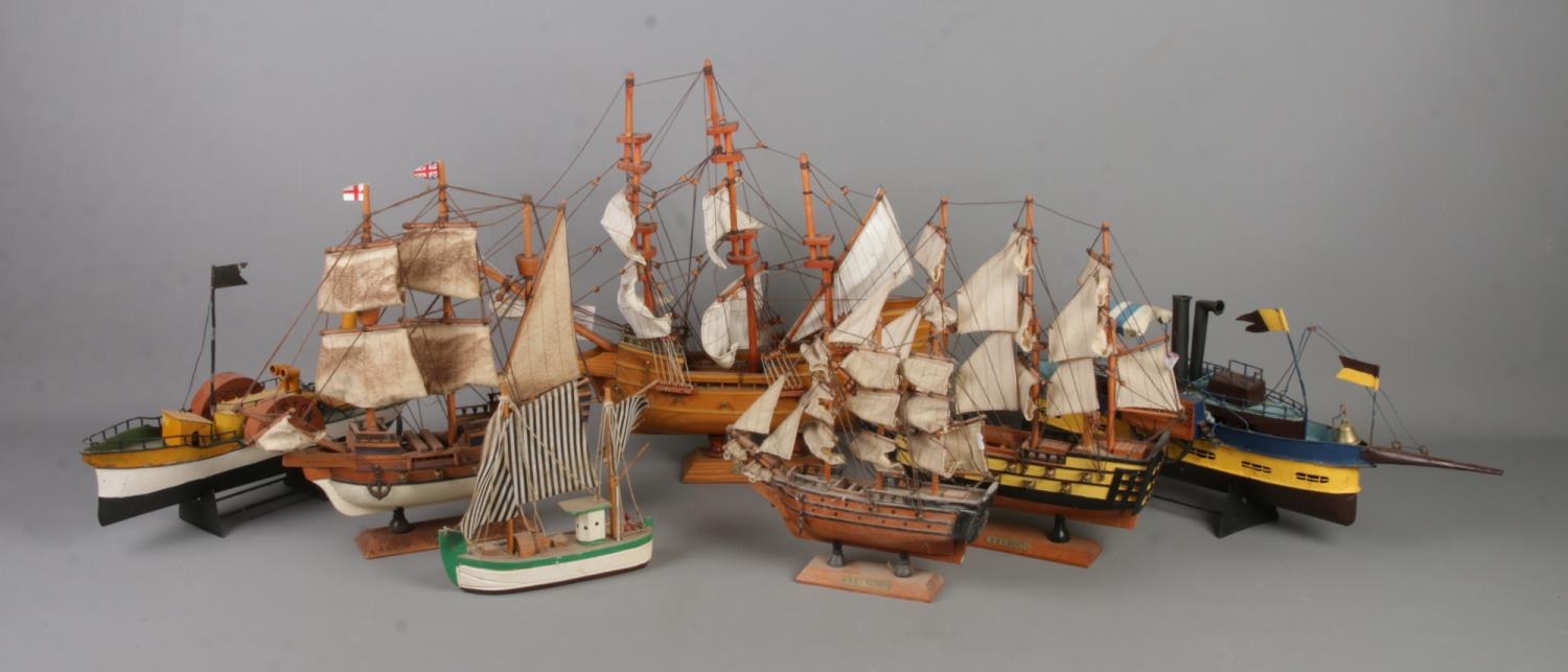 A collection of wooden and metal models of boats/ships. Includes HMS Bounty, HMS Victory, May Flower