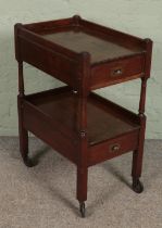 An early 20th century mahogany tea trolley with two drawers.