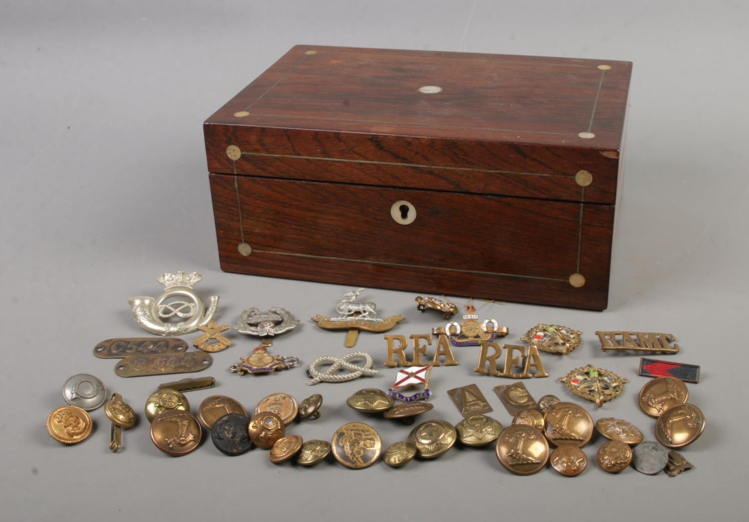 A small collection of military cap badges and buttons to include Egypt East Lancashire, Marine and