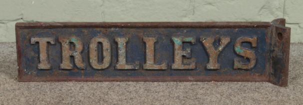 A painted cast iron 'Trolleys' sign. 64cm long.