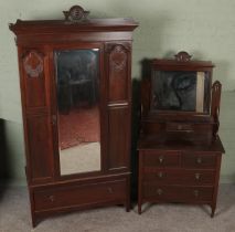 An early 20th century carved mahogany two piece bedroom suite. Comprising of mirror front wardrobe