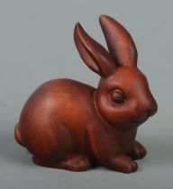 A hand carved hardwood netsuke of a rabbit